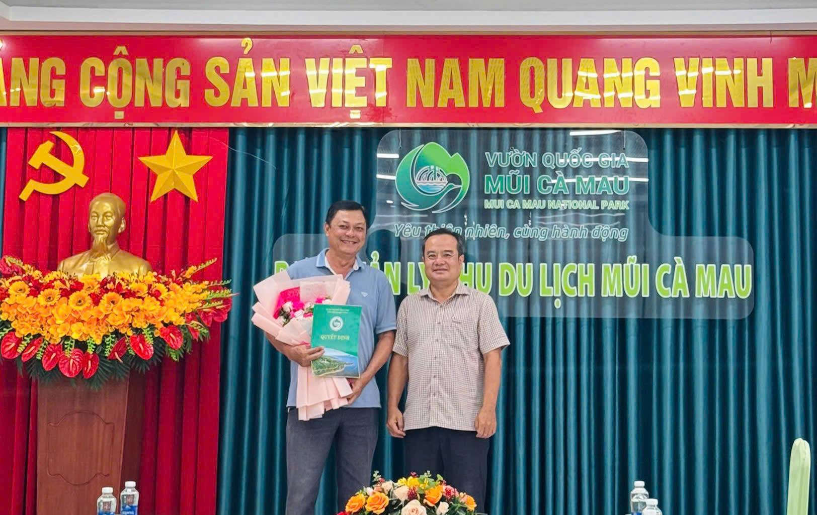 Đồng chí Tạ Huỳnh Vĩnh Trường, Phó Giám đốc Vườn Quốc gia Mũi Cà Mau trao quyết định và hoa chúc mừng đồng chí Phan Thanh Trí